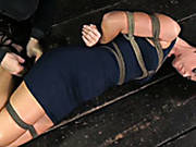 Hard Tied Brunette Wearing Sexy Dress Lies On The Floor