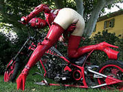 Seductive Woman In Red Latex Costume Pokes Her Twat With Dildo Outdoor